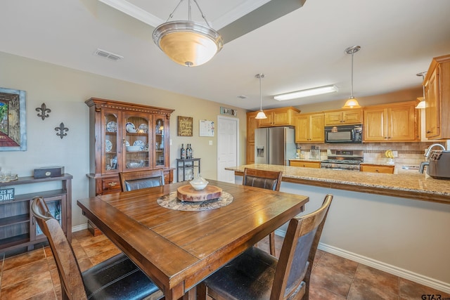 dining space featuring sink and ornamental molding