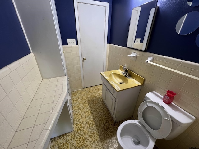 106 Hilltop Dr, Naples, TX 75568 - bathroom featuring tile walls, wainscoting, toilet, vanity, and tile patterned flooring