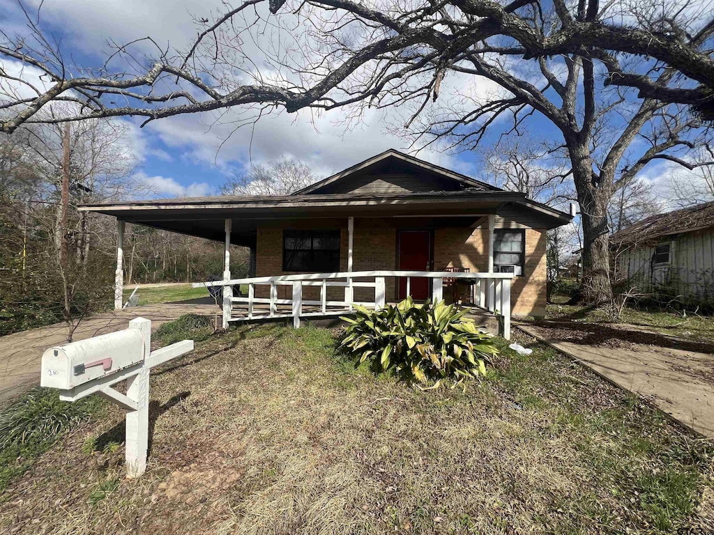 210 Ash St, Crockett, TX 75835 - view of front of house with covered porch and brick siding