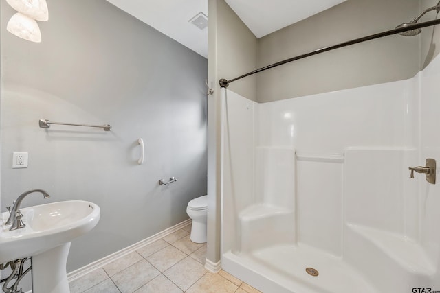 full bath featuring toilet, visible vents, baseboards, a shower, and tile patterned floors