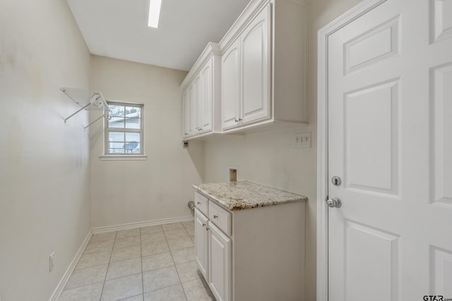 washroom featuring light tile patterned flooring, hookup for a washing machine, cabinet space, and baseboards