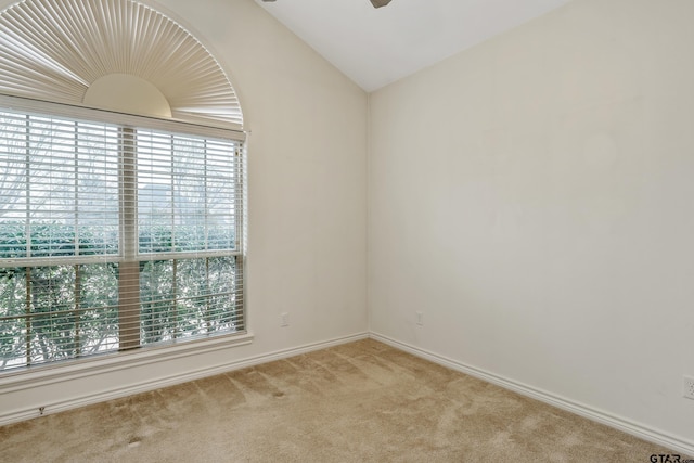 spare room featuring carpet floors, lofted ceiling, a healthy amount of sunlight, and ceiling fan