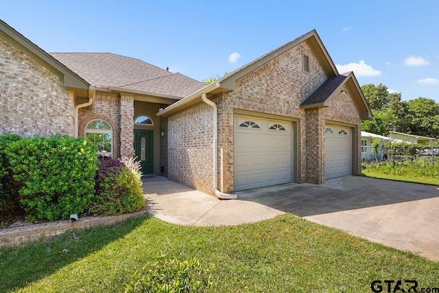 view of front of home with an attached garage, a shingled roof, driveway, and brick siding