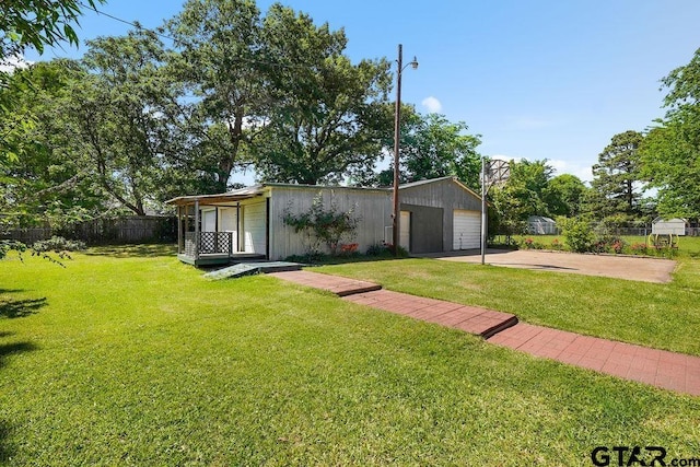 view of front of property with fence, a front lawn, an outdoor structure, and a garage