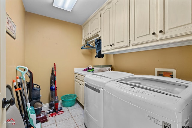 laundry area featuring light tile patterned floors, separate washer and dryer, and cabinets