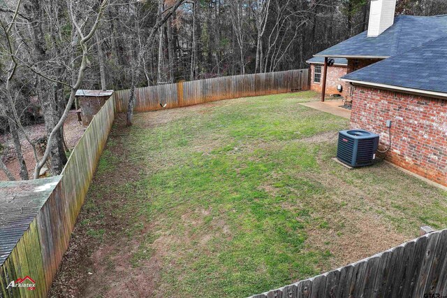 view of yard with central AC and a patio