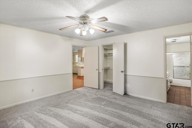 2278 Fm 1799, Mineola, TX 75773 - unfurnished bedroom featuring carpet flooring, a textured ceiling, a spacious closet, ensuite bathroom, and ceiling fan