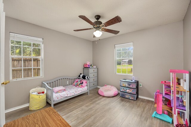 1805 San Saba Dr, Bullard, TX 75757 - bedroom with wood finished floors, a nursery area, and ceiling fan