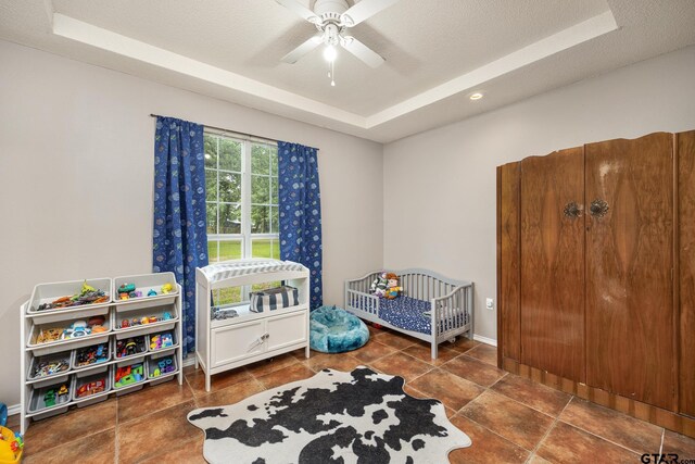 1805 San Saba Dr, Bullard, TX 75757 - tiled bedroom with a raised ceiling, a crib, a textured ceiling, recessed lighting, and ceiling fan
