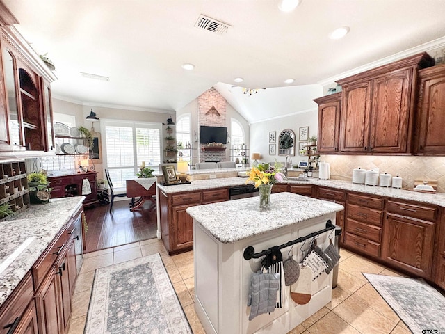 599 N Weldon St, Frankston, TX 75763 - kitchen featuring lofted ceiling, backsplash, a peninsula, a kitchen island, and crown molding