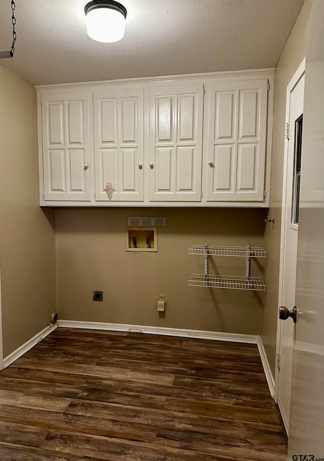 clothes washing area featuring hookup for an electric dryer, cabinets, a textured ceiling, washer hookup, and dark hardwood / wood-style floors