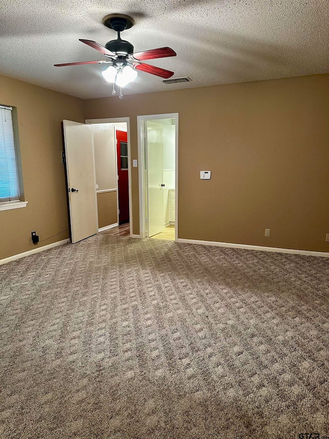 unfurnished bedroom featuring ensuite bathroom, ceiling fan, a textured ceiling, and carpet floors