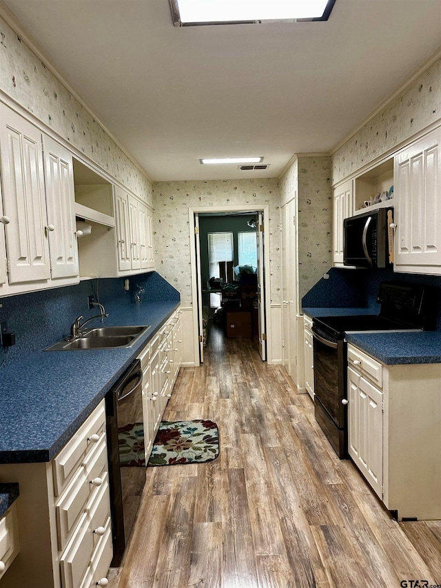 kitchen featuring black appliances, sink, hardwood / wood-style floors, and ornamental molding