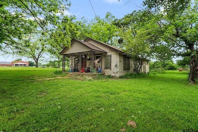exterior space featuring covered porch and a front yard