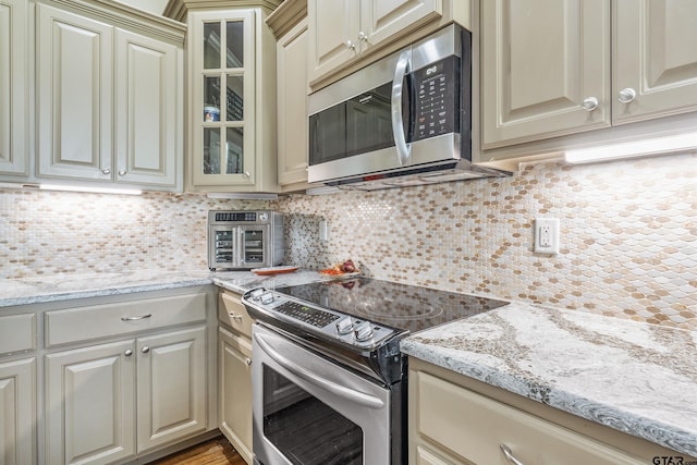 275 Babatwa Ln, Bullard, TX 75757 - kitchen with stainless steel appliances, cream cabinetry, and backsplash