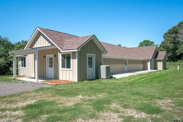 view of side of home with a patio, central AC, and a yard