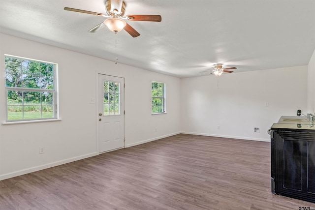 unfurnished living room with hardwood / wood-style floors and ceiling fan