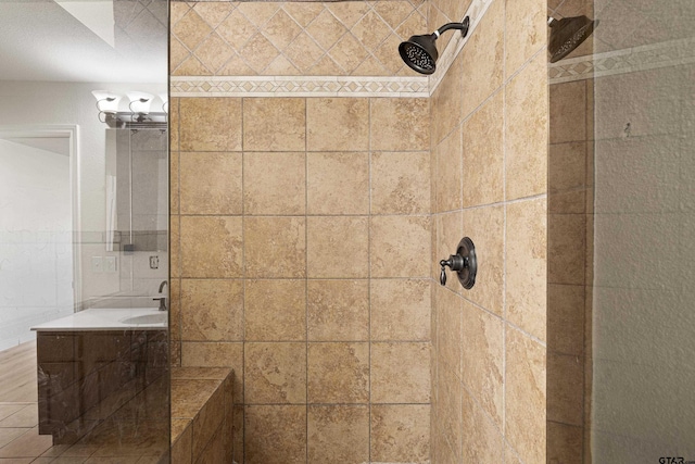 bathroom featuring tile walls, sink, and a tile shower