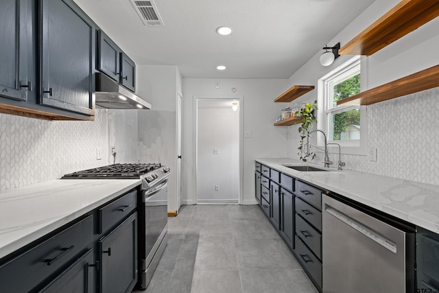 kitchen with stainless steel appliances, sink, light stone counters, light tile patterned floors, and decorative backsplash