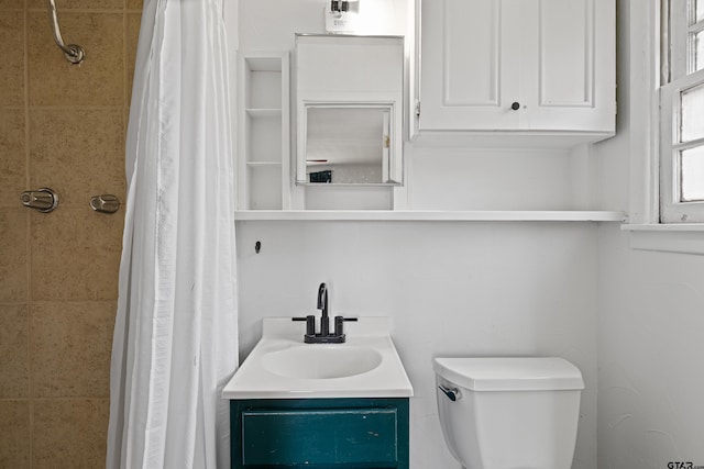 bathroom with walk in shower, vanity, and toilet