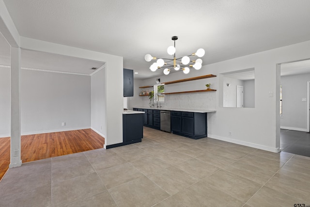 kitchen featuring a textured ceiling, decorative light fixtures, a chandelier, light wood-type flooring, and dishwasher