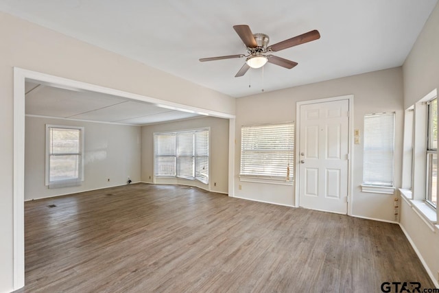 unfurnished living room with wood-type flooring, ceiling fan, and plenty of natural light