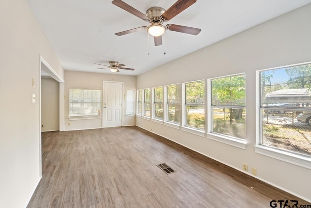 unfurnished sunroom featuring ceiling fan