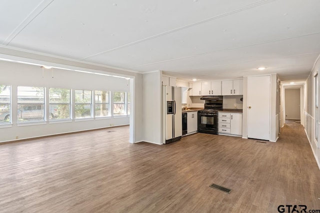 kitchen with black range with gas cooktop, light wood-type flooring, white cabinets, and white fridge with ice dispenser