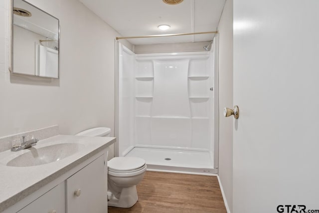 bathroom with toilet, wood-type flooring, a shower, and vanity