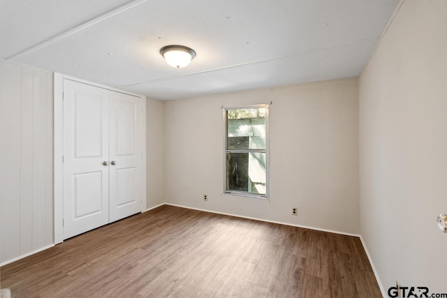 unfurnished bedroom with a closet and hardwood / wood-style flooring