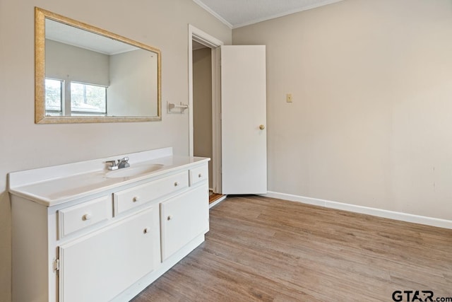 bathroom featuring wood-type flooring, vanity, and crown molding