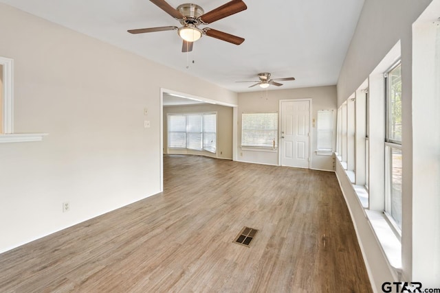 unfurnished living room featuring ceiling fan and hardwood / wood-style floors