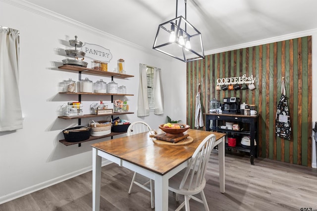 dining area with hardwood / wood-style floors, a chandelier, and crown molding