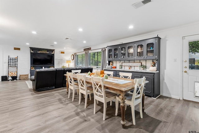 dining space featuring light hardwood / wood-style floors and ornamental molding