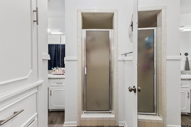 bathroom with vanity, hardwood / wood-style flooring, and a shower with shower door