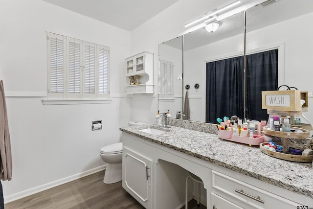 bathroom featuring vanity, hardwood / wood-style flooring, and toilet