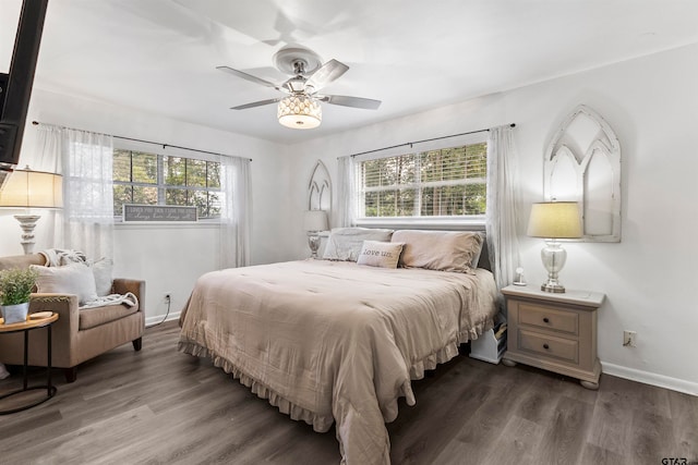 bedroom featuring ceiling fan, multiple windows, and dark hardwood / wood-style flooring