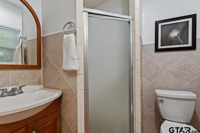 full bath featuring vanity, a shower stall, toilet, and tile walls