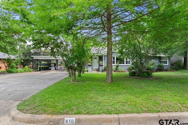 obstructed view of property featuring an attached carport, concrete driveway, and a front lawn