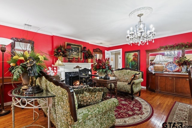living room featuring visible vents, crown molding, a chandelier, hardwood / wood-style floors, and a premium fireplace