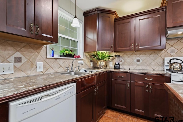 kitchen featuring backsplash, white dishwasher, pendant lighting, a sink, and stone countertops
