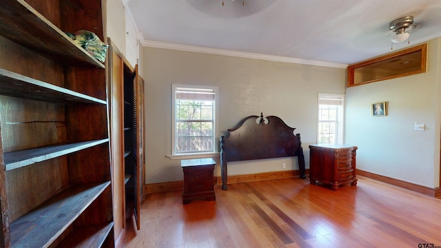 bedroom featuring hardwood / wood-style floors, ceiling fan, and crown molding