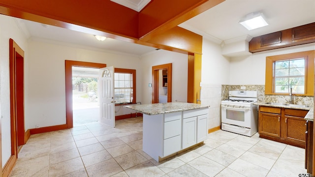 kitchen featuring white gas range oven, crown molding, a healthy amount of sunlight, and sink