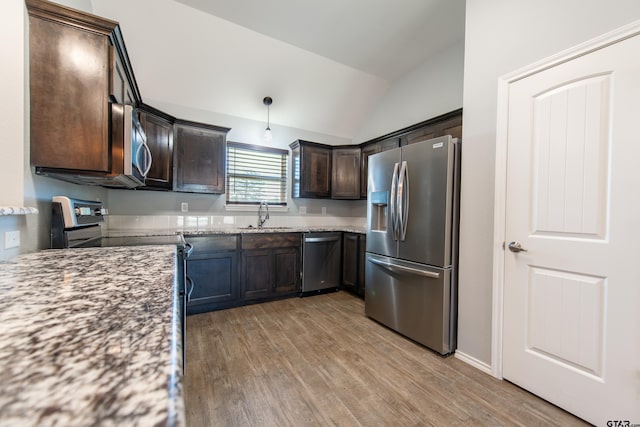 107 Oliver Wendell Ct, Mount Vernon, TX 75457 - kitchen with appliances with stainless steel finishes, a sink, vaulted ceiling, dark brown cabinets, and light wood-style flooring