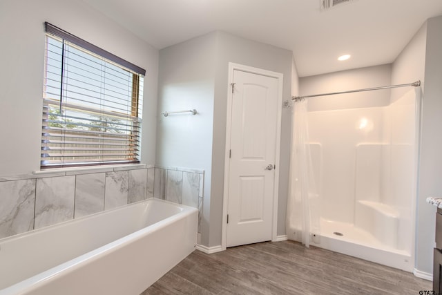 107 Oliver Wendell Ct, Mount Vernon, TX 75457 - full bathroom with wood finished floors, a shower stall, a garden tub, baseboards, and recessed lighting
