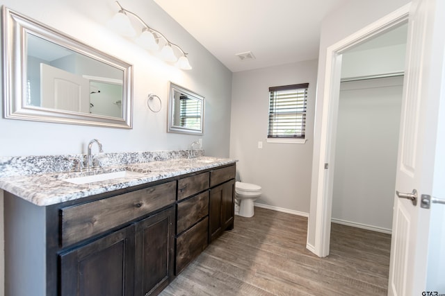 107 Oliver Wendell Ct, Mount Vernon, TX 75457 - full bathroom featuring wood finished floors, toilet, double vanity, and baseboards