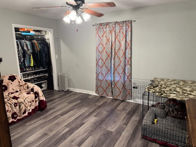 bedroom featuring radiator, ceiling fan, dark hardwood / wood-style flooring, and a closet