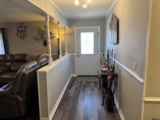 doorway to outside with a textured ceiling, dark hardwood / wood-style flooring, crown molding, and a notable chandelier