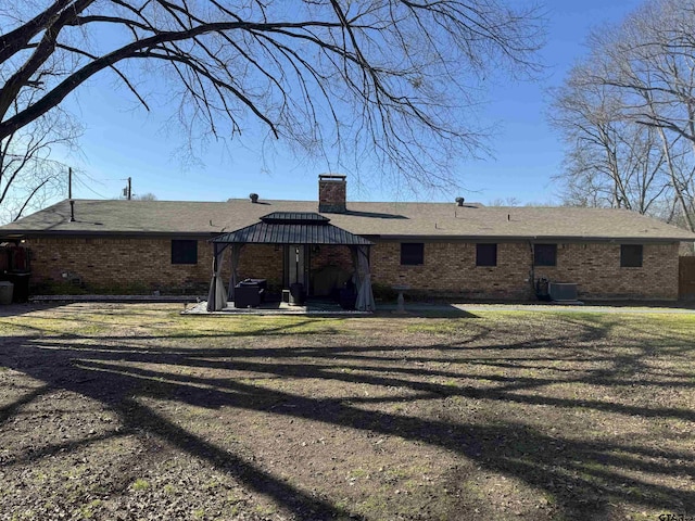 rear view of property with a gazebo and a yard