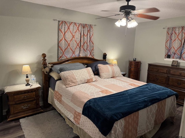 bedroom featuring ceiling fan, dark wood-type flooring, and a textured ceiling